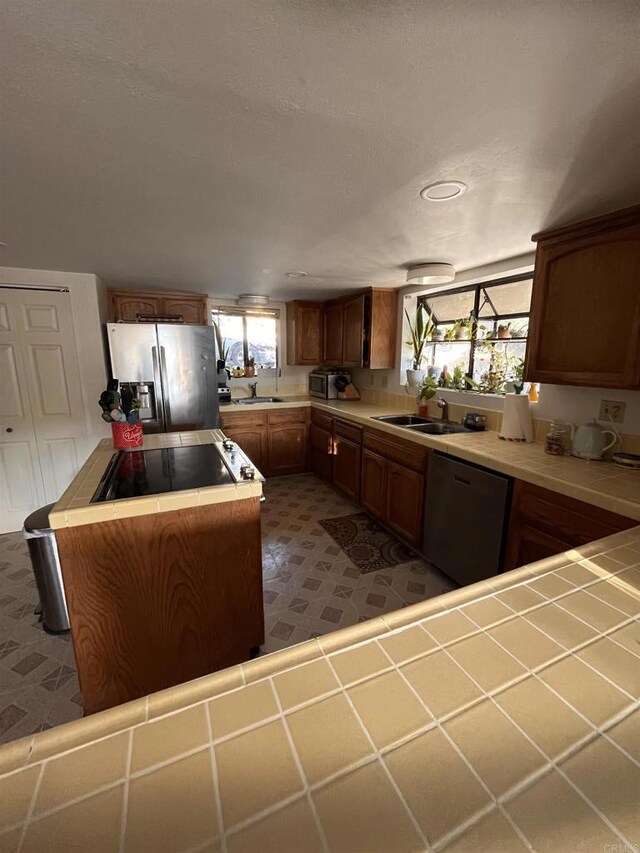 8606 Valley View Trl, Pine Valley, CA 91962 - kitchen featuring stainless steel appliances, tile counters, a kitchen island, brown cabinets, and recessed lighting