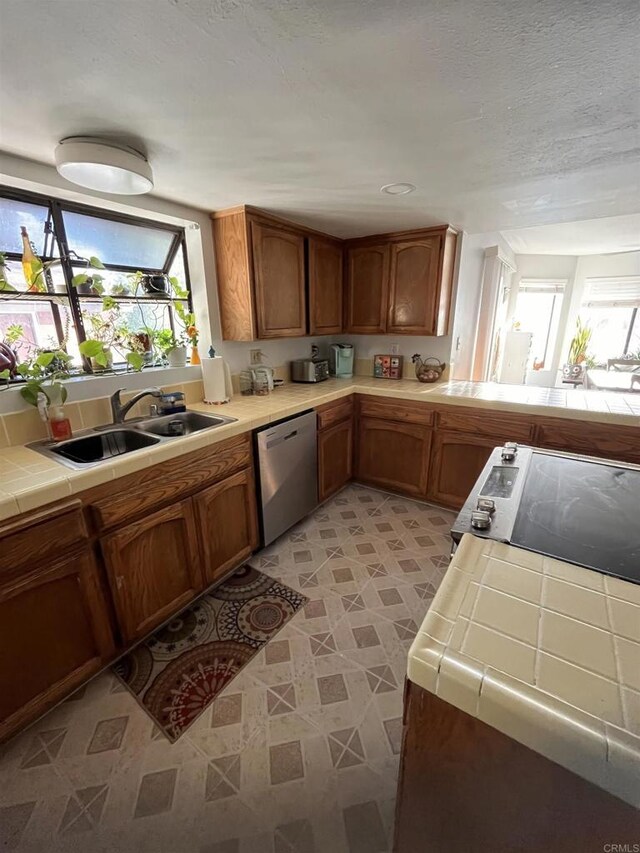 8606 Valley View Trl, Pine Valley, CA 91962 - kitchen with dishwasher, tile counters, plenty of natural light, brown cabinets, and a textured ceiling
