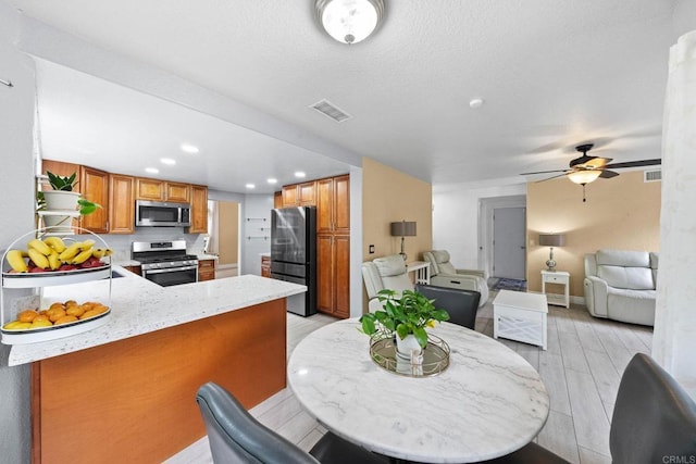 653 Diamond Dr, Chula Vista, CA 91911 - kitchen featuring appliances with stainless steel finishes, brown cabinetry, open floor plan, a peninsula, and recessed lighting