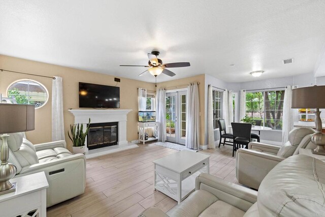 653 Diamond Dr, Chula Vista, CA 91911 - living room with ceiling fan, light wood-style floors, and a glass covered fireplace