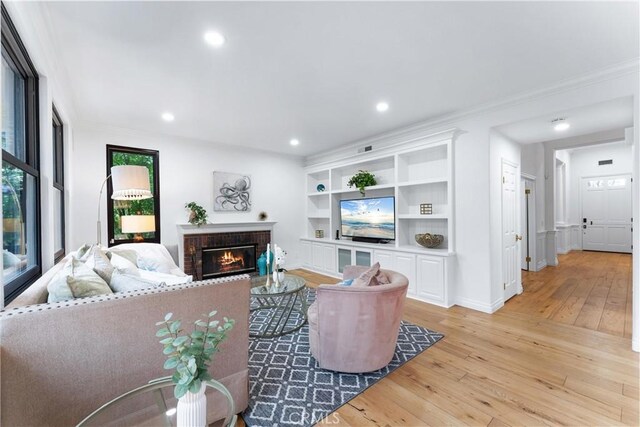 23 Fawnridge Pl, Aliso Viejo, CA 92656 - living area with light wood-style flooring, crown molding, a fireplace, recessed lighting, and built in shelves