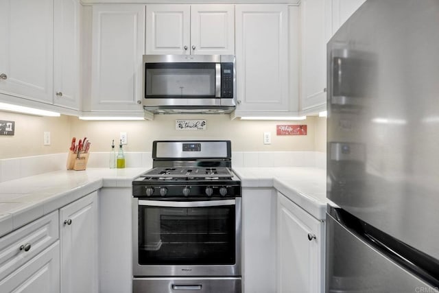 4049 Peninsula Dr, Carlsbad, CA 92010 - kitchen featuring appliances with stainless steel finishes, white cabinets, and tile counters