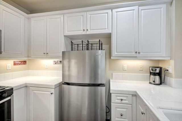 4049 Peninsula Dr, Carlsbad, CA 92010 - kitchen with stainless steel appliances, tile countertops, and white cabinets