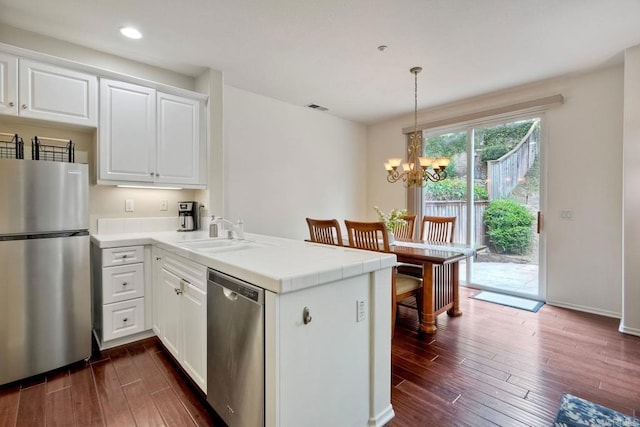 4049 Peninsula Dr, Carlsbad, CA 92010 - kitchen with stainless steel appliances, a peninsula, dark wood finished floors, a chandelier, and recessed lighting