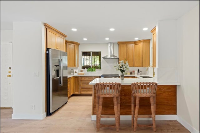 2610 Torrey Pines Rd Unit C21, La Jolla, CA 92037 - kitchen featuring appliances with stainless steel finishes, wall chimney range hood, a peninsula, light countertops, and light wood finished floors