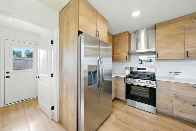 640 Pyramid St, San Diego, CA 92114 - kitchen featuring appliances with stainless steel finishes, wall chimney exhaust hood, light countertops, light wood-type flooring, and backsplash