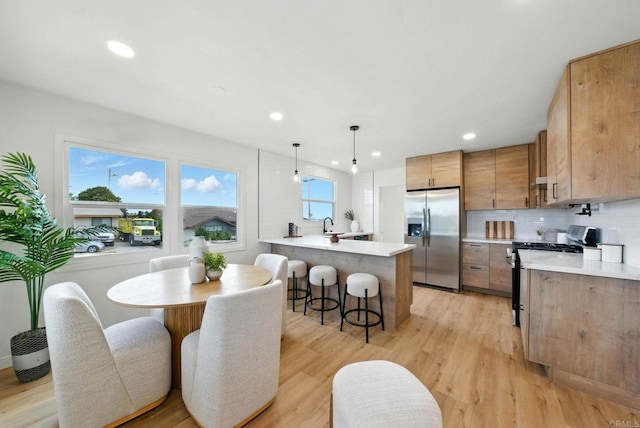 640 Pyramid St, San Diego, CA 92114 - kitchen featuring stainless steel refrigerator with ice dispenser, gas range oven, a peninsula, a kitchen breakfast bar, and light countertops