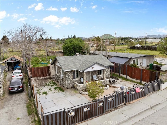 671 N Cherry St, Banning, CA 92220 - view of front of house featuring stone siding, a fenced front yard, a gate, and roof with shingles