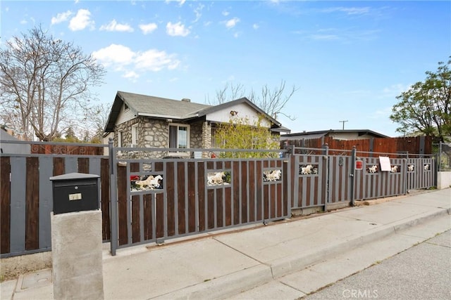 671 N Cherry St, Banning, CA 92220 - view of front of home with a gate, a fenced front yard, and stone siding