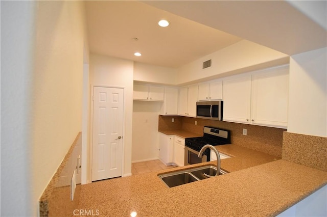 2 Lynde St, Ladera Ranch, CA 92694 - kitchen with stainless steel appliances, recessed lighting, backsplash, white cabinets, and a peninsula