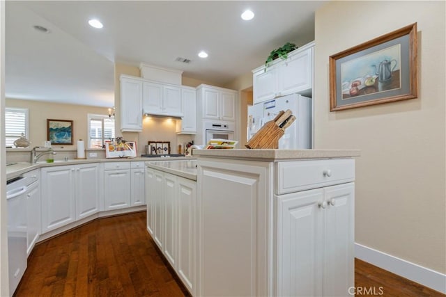 2747 Traditions Loop, Paso Robles, CA 93446 - kitchen with white appliances, a kitchen island, white cabinetry, light countertops, and dark wood finished floors
