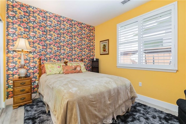 2747 Traditions Loop, Paso Robles, CA 93446 - bedroom featuring an accent wall, wallpapered walls, and wood finished floors