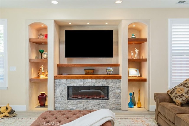 2747 Traditions Loop, Paso Robles, CA 93446 - living area featuring built in shelves, a stone fireplace, wood finished floors, and recessed lighting