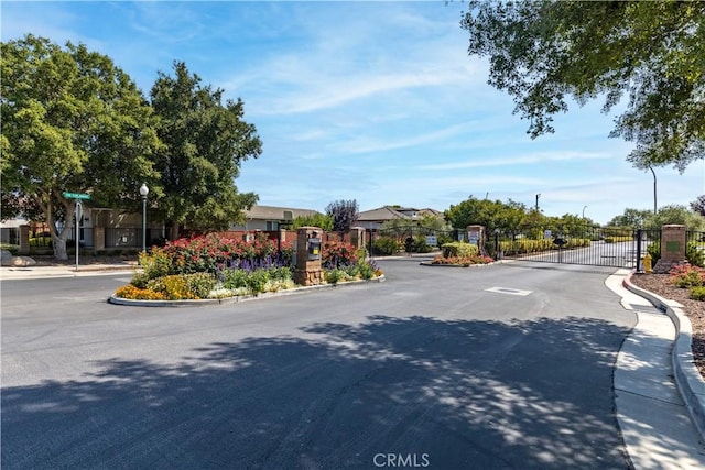 2747 Traditions Loop, Paso Robles, CA 93446 - view of asphalt street featuring a gate, curbs, a gated entry, and street lights