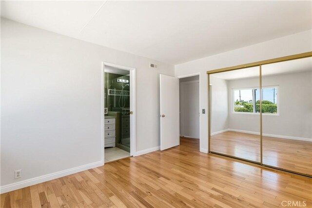 10402 Oronsay Cir, Huntington Beach, CA 92646 - unfurnished bedroom with light wood finished floors, a closet, and connected bathroom