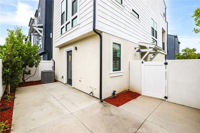 536 Caleigh Ln, Costa Mesa, CA 92627 - view of home's exterior with a gate, cooling unit, stucco siding, and a patio area