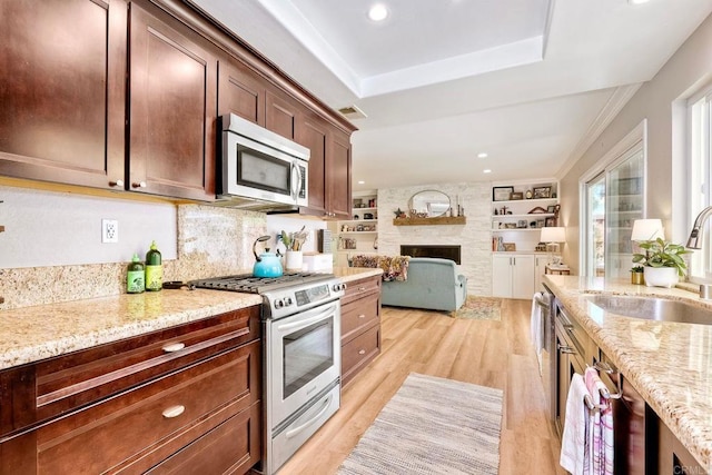 5431 Stirrup Way, Oceanside, CA 92057 - kitchen with appliances with stainless steel finishes, a raised ceiling, light wood-style flooring, light stone counters, and open floor plan