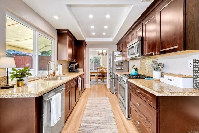 5431 Stirrup Way, Oceanside, CA 92057 - kitchen featuring appliances with stainless steel finishes, light wood-style floors, recessed lighting, a raised ceiling, and backsplash