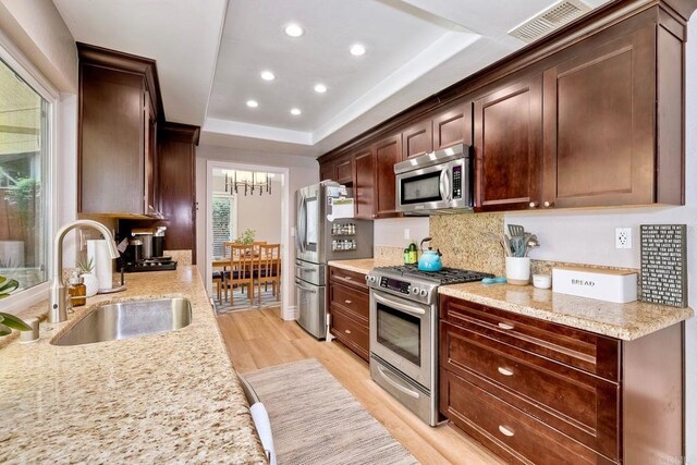 5431 Stirrup Way, Oceanside, CA 92057 - kitchen featuring appliances with stainless steel finishes, light wood-type flooring, decorative backsplash, a raised ceiling, and recessed lighting