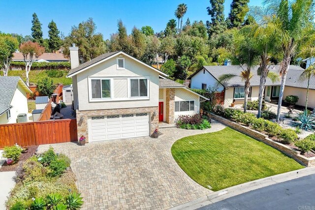 5431 Stirrup Way, Oceanside, CA 92057 - view of front facade featuring decorative driveway, an attached garage, stone siding, stucco siding, and a chimney