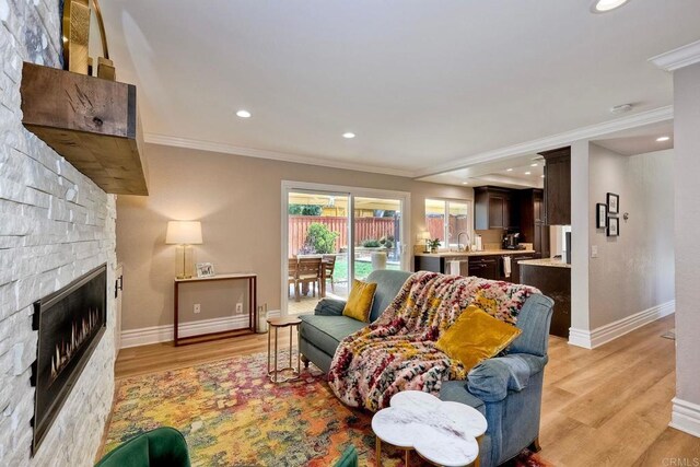 5431 Stirrup Way, Oceanside, CA 92057 - living area with crown molding, a stone fireplace, light wood-type flooring, and recessed lighting