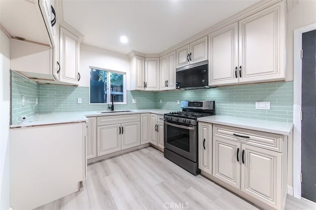 210 Amabel St, Los Angeles, CA 90065 - kitchen featuring stainless steel gas range, light countertops, tasteful backsplash, and light wood-style floors