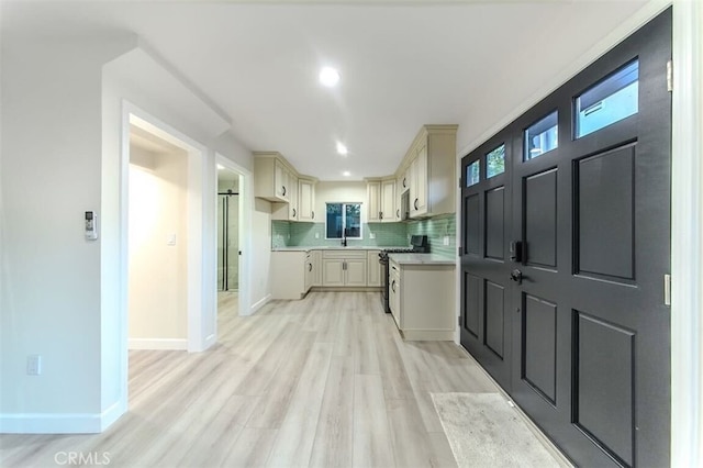 210 Amabel St, Los Angeles, CA 90065 - kitchen with gas range oven, light countertops, light wood-type flooring, tasteful backsplash, and cream cabinetry