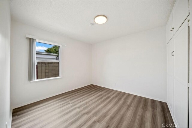 823 W 25th St, San Pedro, CA 90731 - spare room featuring wood finished floors, baseboards, and a textured ceiling