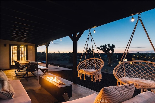 58250 Sierra Vista Dr, Yucca Valley, CA 92284 - patio terrace at dusk with an outdoor fire pit, outdoor dining space, and a patio