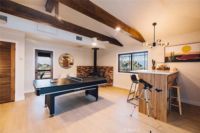 58250 Sierra Vista Dr, Yucca Valley, CA 92284 - recreation room featuring baseboards, light wood-type flooring, beamed ceiling, and a wood stove