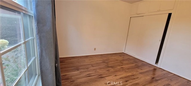 1623 S Sycamore Ave, Los Angeles, CA 90019 - unfurnished bedroom with multiple windows, wood finished floors, and a closet