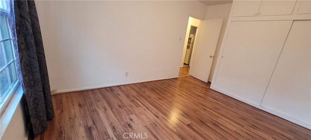 1623 S Sycamore Ave, Los Angeles, CA 90019 - unfurnished bedroom with wood finished floors and a closet