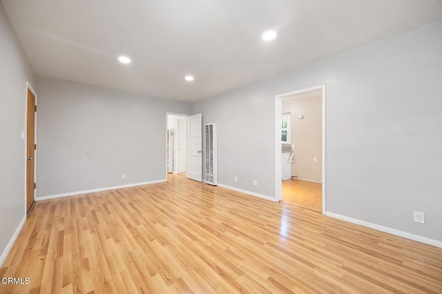  - unfurnished bedroom with light wood finished floors, a heating unit, recessed lighting, and ensuite bath
