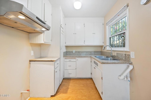  - kitchen with exhaust hood, white cabinetry, light wood finished floors, and light countertops