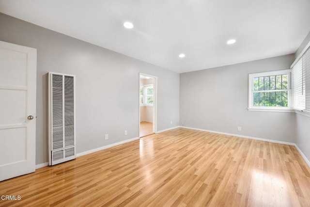  - unfurnished room with a heating unit, healthy amount of natural light, light wood finished floors, and recessed lighting