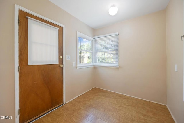  - doorway with wood finished floors and baseboards