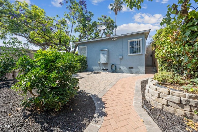  - rear view of house featuring stucco siding, crawl space, and a patio area