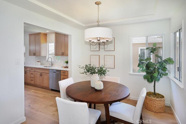 9864 Van Ruiten St, Bellflower, CA 90706 - dining area with light wood-type flooring, healthy amount of natural light, a raised ceiling, and a chandelier