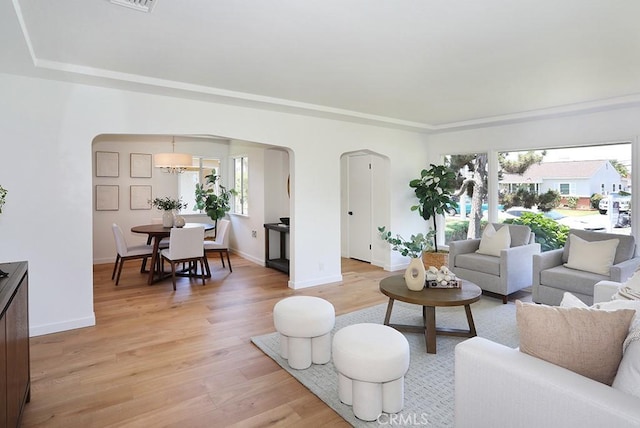 9864 Van Ruiten St, Bellflower, CA 90706 - living room featuring arched walkways, plenty of natural light, and light wood-style floors