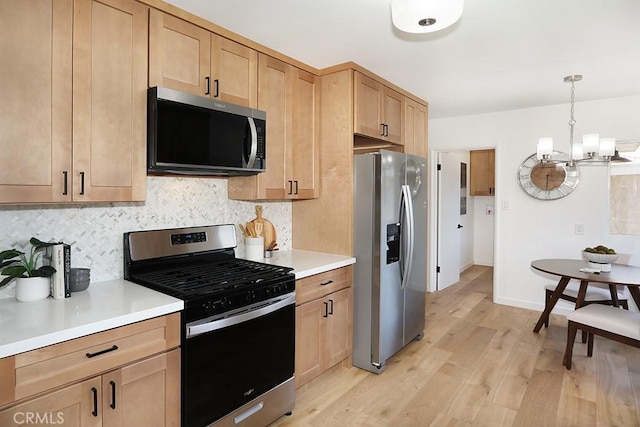 9864 Van Ruiten St, Bellflower, CA 90706 - kitchen with stainless steel appliances, a chandelier, light wood-style flooring, and tasteful backsplash