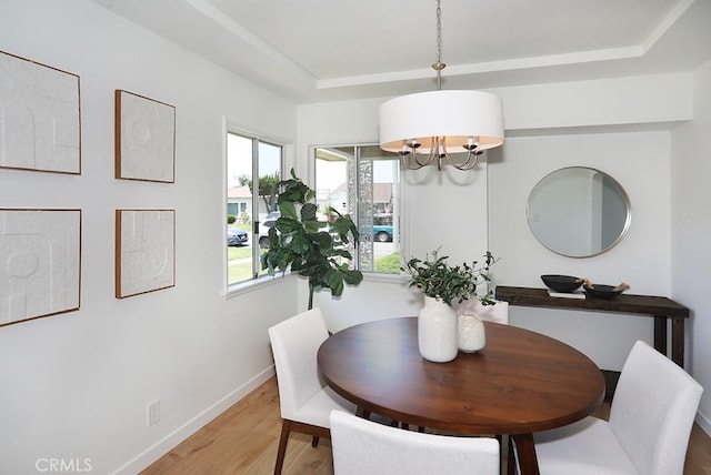 9864 Van Ruiten St, Bellflower, CA 90706 - dining space featuring light wood-style flooring, a raised ceiling, and a chandelier