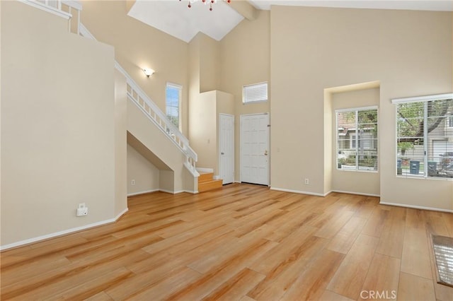28462 La Alcala, Laguna Niguel, CA 92677 - unfurnished living room with high vaulted ceiling, wood finished floors, beam ceiling, and stairway