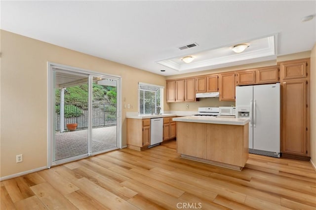 28462 La Alcala, Laguna Niguel, CA 92677 - kitchen with white appliances, a raised ceiling, light countertops, light wood-style floors, and a kitchen island