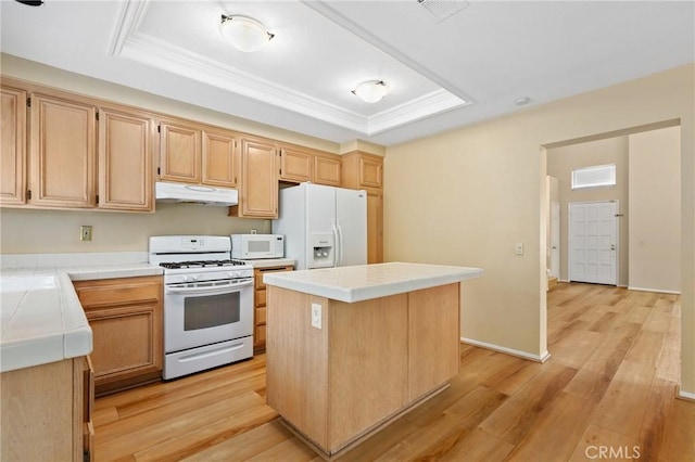 28462 La Alcala, Laguna Niguel, CA 92677 - kitchen featuring white appliances, tile counters, under cabinet range hood, a tray ceiling, and light wood finished floors