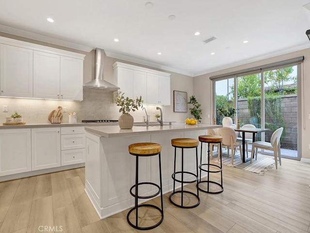 159 Frazier, Irvine, CA 92620 - kitchen featuring wall chimney range hood, a sink, light wood-style flooring, ornamental molding, and backsplash