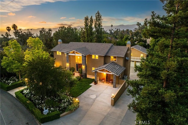 1377 Knoll Rd, Redlands, CA 92373 - view of front of house featuring a chimney, stone siding, driveway, stucco siding, and a standing seam roof