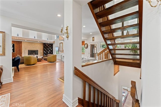 1377 Knoll Rd, Redlands, CA 92373 - stairway featuring wood finished floors, recessed lighting, ornamental molding, and a fireplace