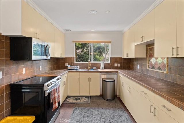 1377 Knoll Rd, Redlands, CA 92373 - kitchen featuring appliances with stainless steel finishes, tile counters, cream cabinets, crown molding, and backsplash