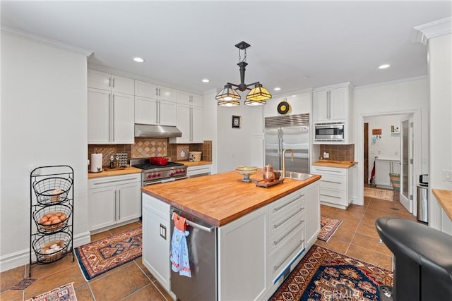 1377 Knoll Rd, Redlands, CA 92373 - kitchen featuring built in appliances, butcher block countertops, under cabinet range hood, tile patterned floors, and backsplash