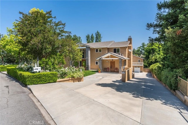1377 Knoll Rd, Redlands, CA 92373 - view of front facade with driveway, stucco siding, a chimney, and an attached garage